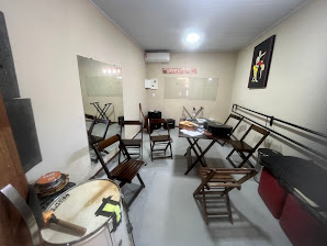 Sala com instrumentos e cadeiras da sede atual da escola